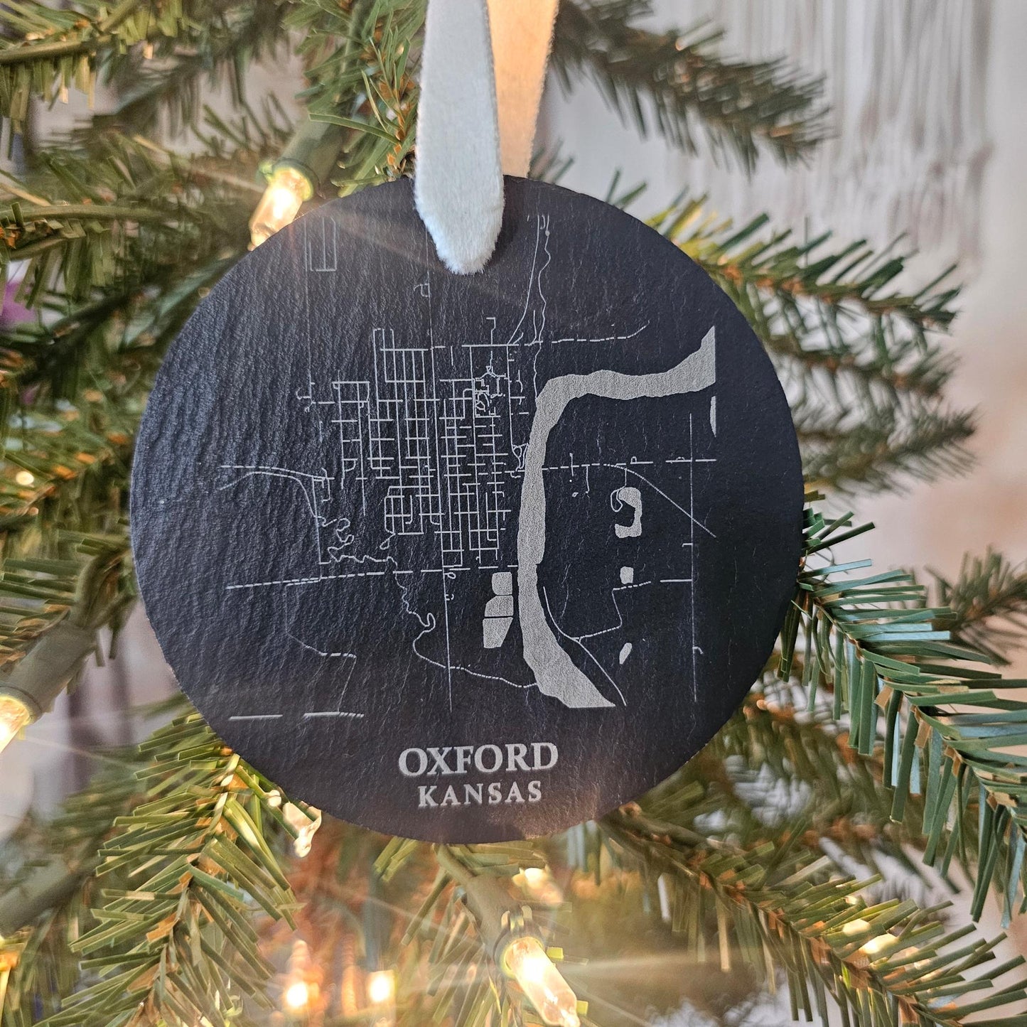 Engraved slate ornament with the city map of Oxford, Kansas and kraft packaging